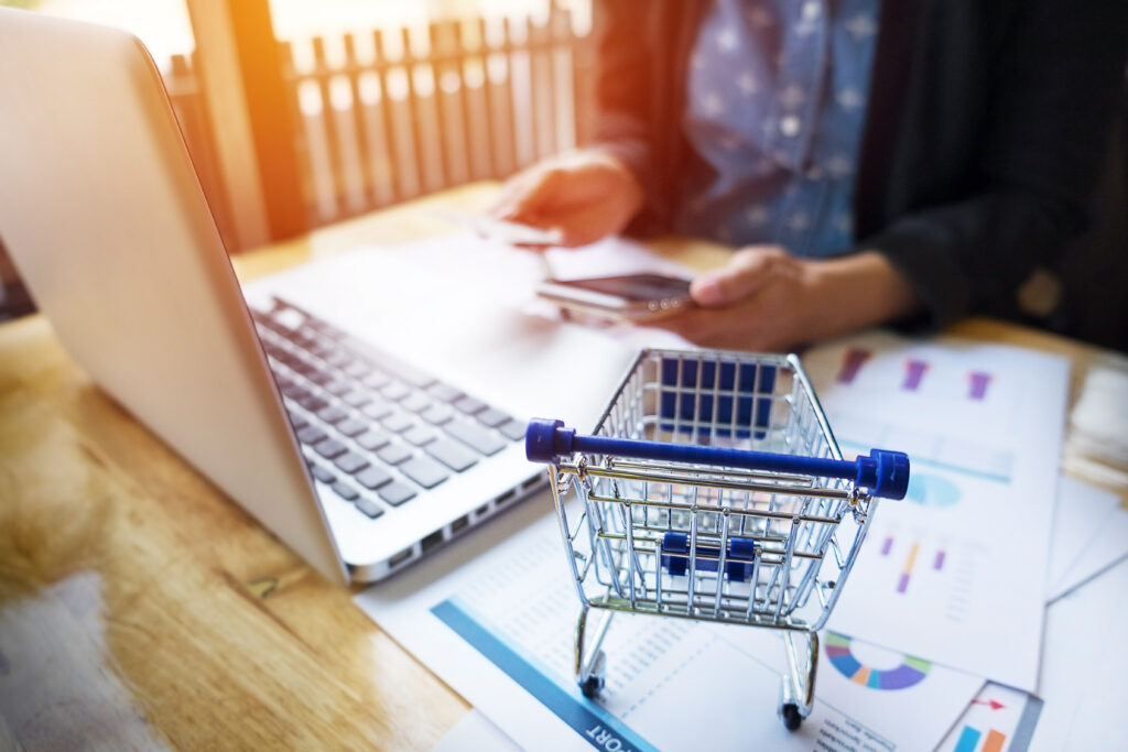 woman inputting card information key phon laptop while shopping online